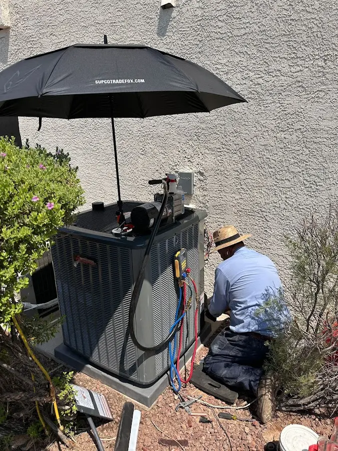 HVAC technician performing outdoor AC maintenance in Chelsea